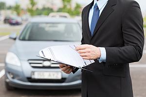 Auto insurance agent in front of car