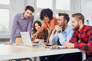 Group of diverse employees at computer 