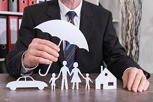 Man holding paper umbrella over personal insurance items