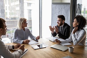 Smaller business meeting in conference room to discuss fiduciary liability insurance