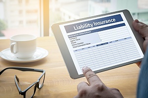 a small business owner looking at general liability insurance options on his tablet