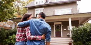 Couple in front of home with home insurance