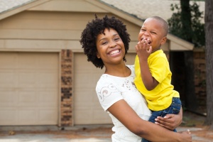 women outside her home with her kid that has HOA Insurance