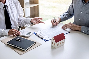 a homeowner signing a landlord insurance policy with an agent