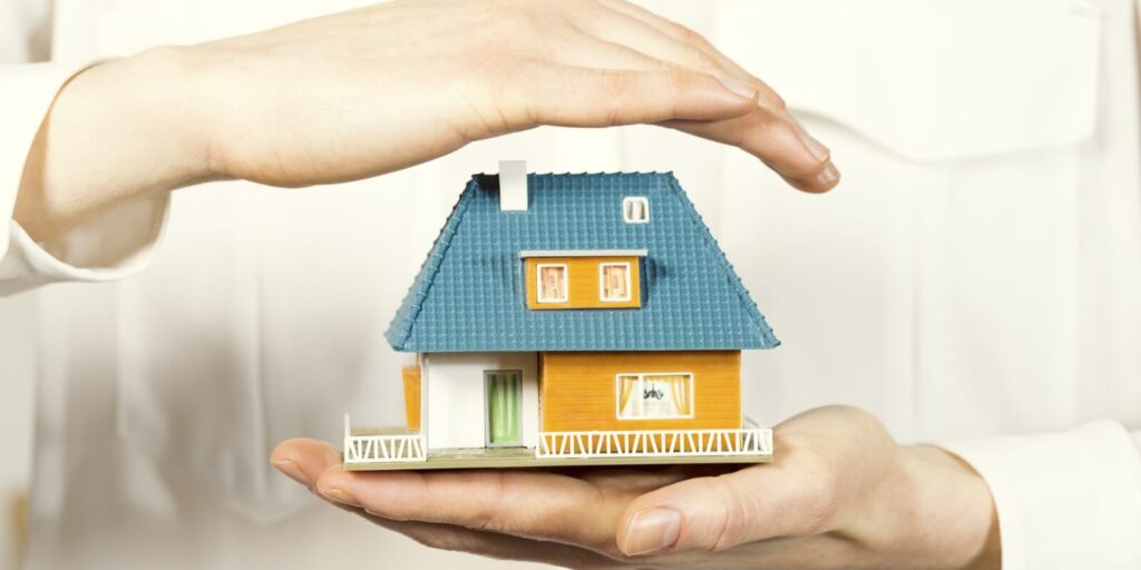 hand hovering small family house