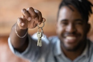 man holding home keys in hand