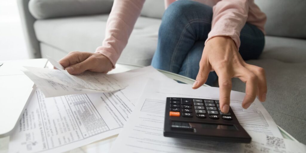 renter holding paper bills using calculator for business financial