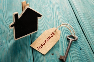 home insurance concept with a key lables with an insurance tag and a house clip