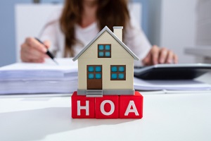 house model over hoa blocks in front of businesswoman
