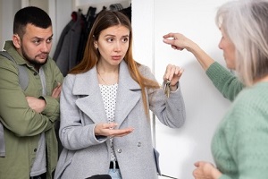 owner of apartment receiving keys from married couple tenants