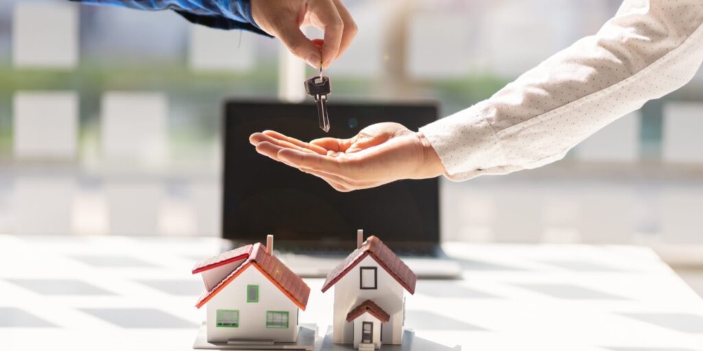 real estate agent hands the customer the keys to the house after the contract agreement is complete