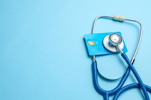 credit card with stethoscope on blue background
