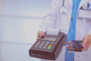 doctor offering swipe machine for hospital bill payment