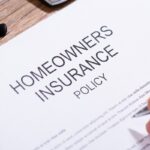 person filling homeowners insurance policy form