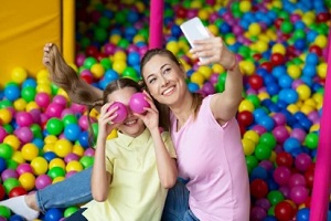 mother daughter taking selfie in fun entertainment center