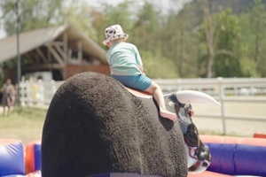 small boy riding mechanical bull