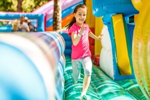 happy little girl having lots of fun on a jumping castle during sliding