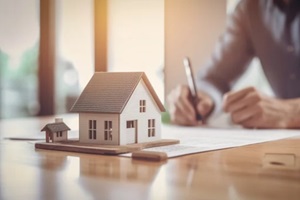 house model with business man signs a purchase contract