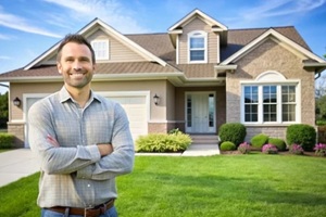 happy homeowner posing in front of new house