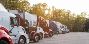 semi-trucks lined up neatly at a rest stop during golden hour