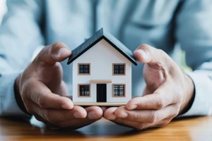 man holding small home dummy