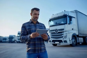 man using tablet outside a truck