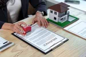 real estate agent stamping an insurance policy document for a new house