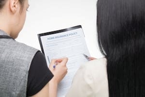 People Reviewing Home Insurance Policy Form