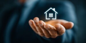 Man Holding Glowing Home Icon Showing Insurance Concept