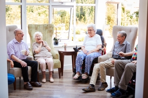 Smiling Elderly People Talking to Each Other in An Assisted Living Lounge